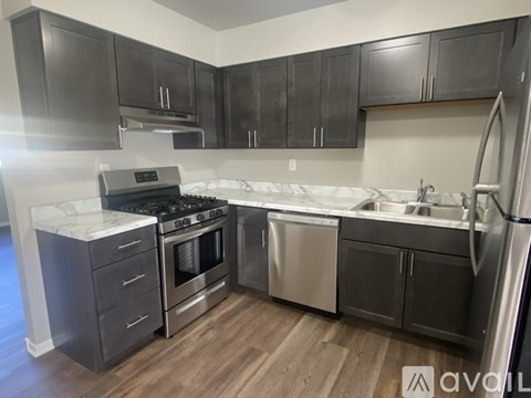 A kitchen with dark wood cabinets and stainless steel appliances.