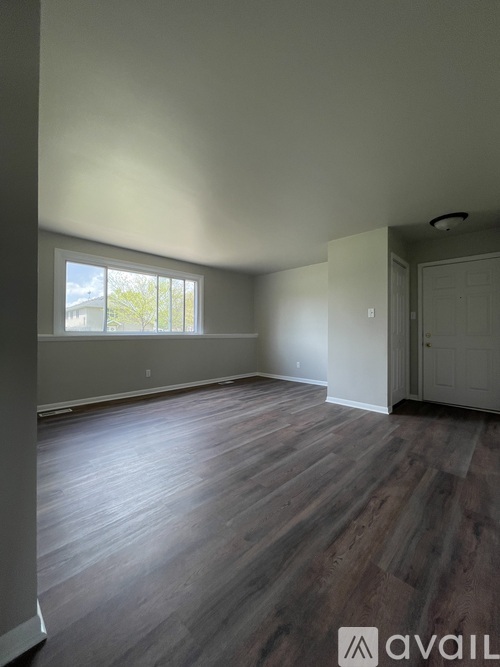 A room with wooden flooring and a window.