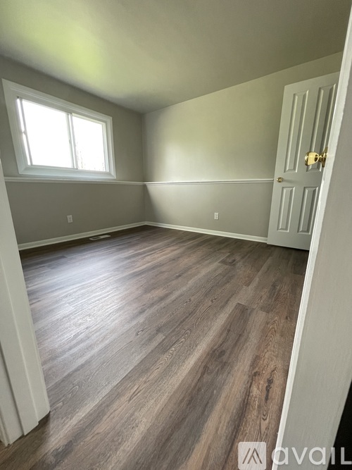 A room with a wooden floor and a white door.