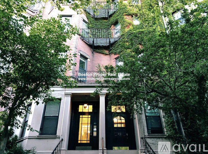 A building with a balcony covered in greenery.