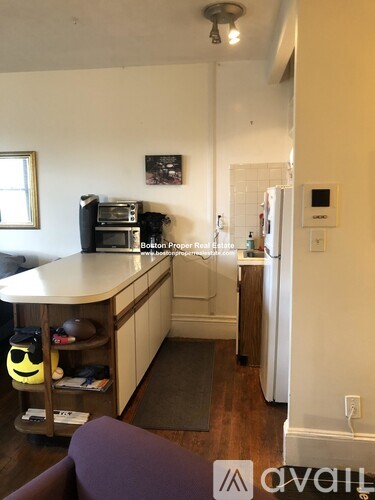 A kitchen with a white refrigerator and a purple couch.
