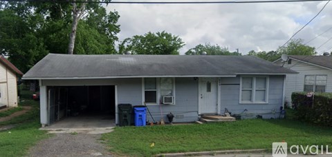 A small house with a garage door open.