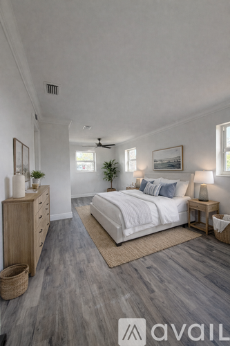 A bedroom with a bed, nightstand, and a dresser with a plant on top.