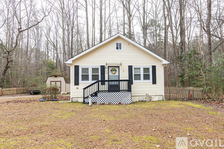 A small white house with a black and white checkered front porch.