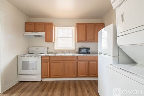 A kitchen with wooden cabinets and white appliances.