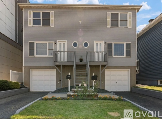 A two-story house with a balcony on the second floor.