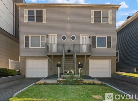 A two-story house with a balcony on the second floor.