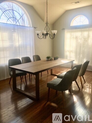 A dining room with a wooden table and chairs.