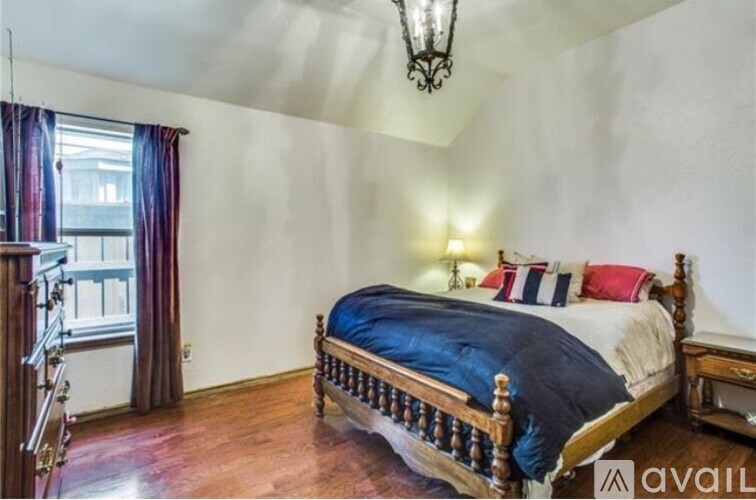 A bedroom with a large bed and a chandelier.