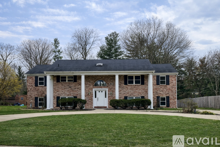 A house with a white front door and a large front lawn.