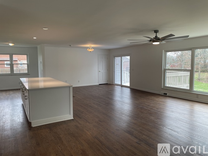 A spacious room with a long table and a ceiling fan.