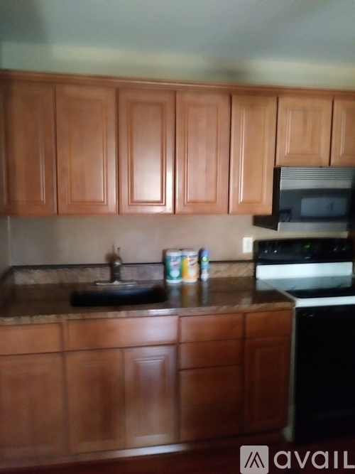 A kitchen with wooden cabinets and a black stove.