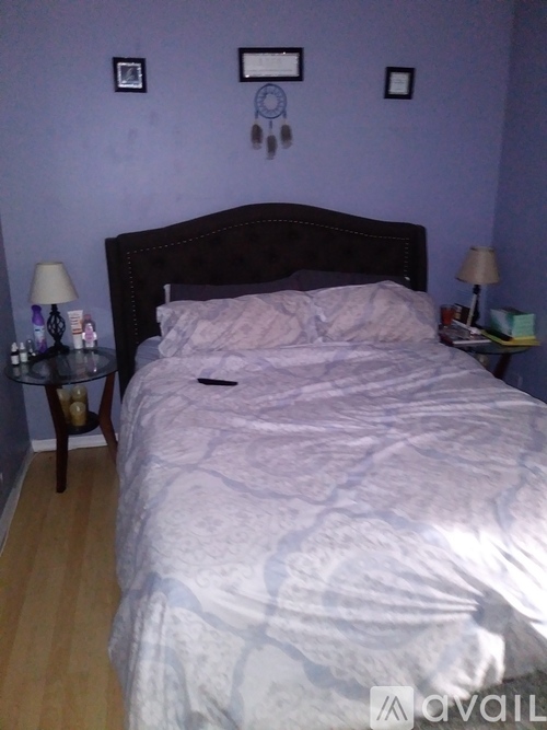 A bed with a white comforter and a wooden headboard.