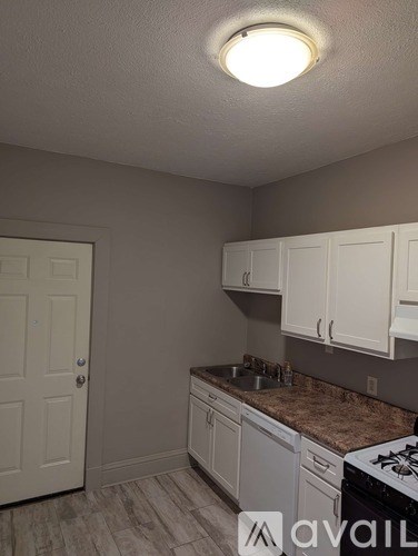 A kitchen with white cabinets and a black stove top oven.