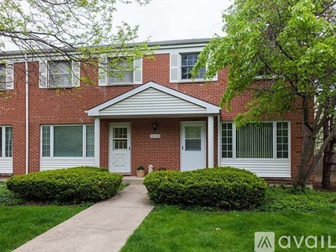 A red brick house with a white door and windows.
