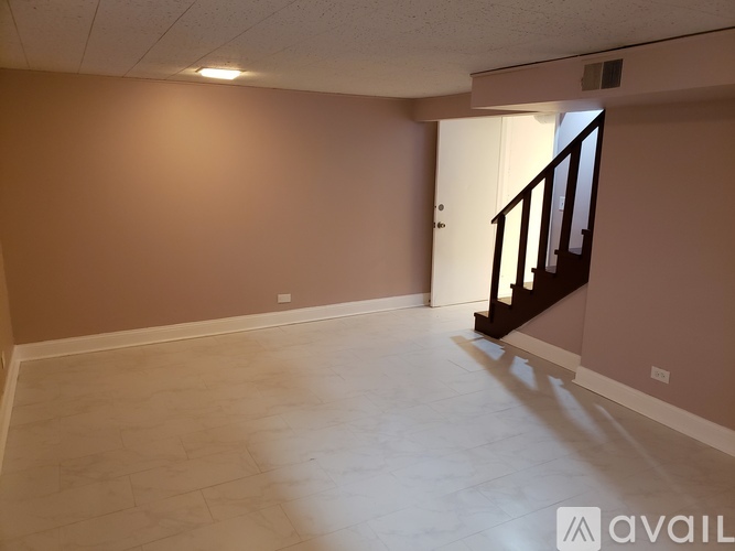 A room with a staircase and a light brown wall.
