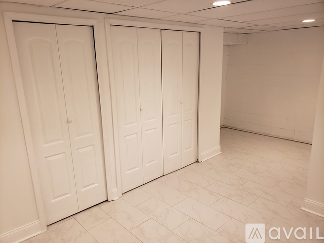 Three white doors in a room with tiled flooring.