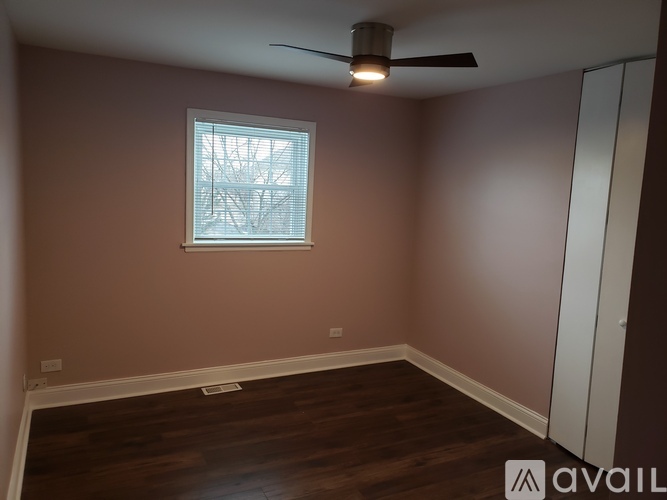 A room with a window and a ceiling fan.