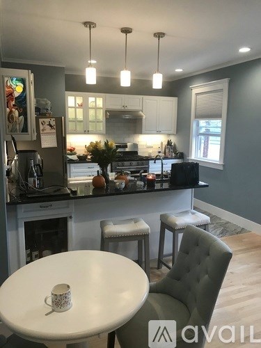 A kitchen with a table and chairs in front of it.