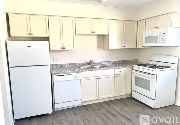 A kitchen with white appliances and cabinets.