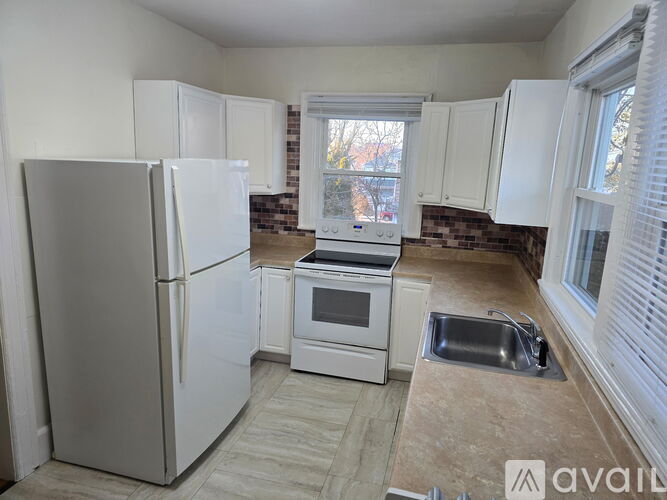 A kitchen with a refrigerator, oven, and sink.