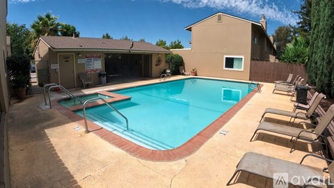 A pool with a red border and a house in the background.