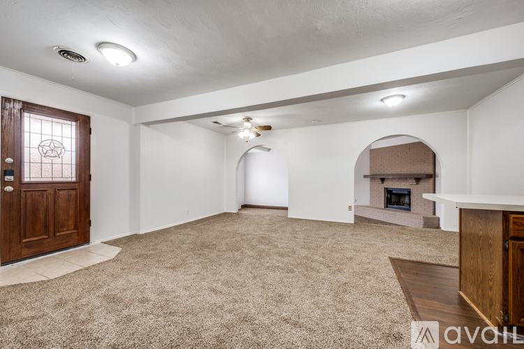 A spacious living room with a fireplace and a carpeted floor.