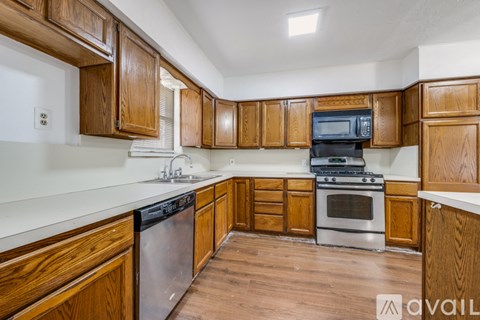 A kitchen with wooden cabinets and stainless steel appliances.