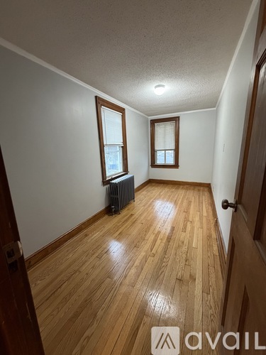 A room with wooden floors and two windows.