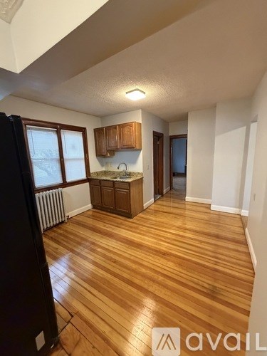A kitchen with wooden floors and white walls.