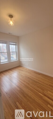 A room with wooden flooring and a window.