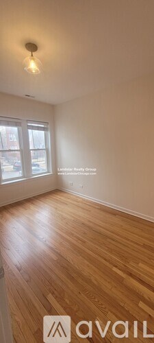 A room with wooden flooring and a window.