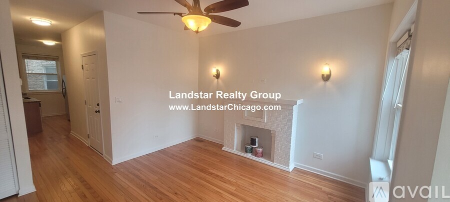 A large empty room with a fireplace and a fan.