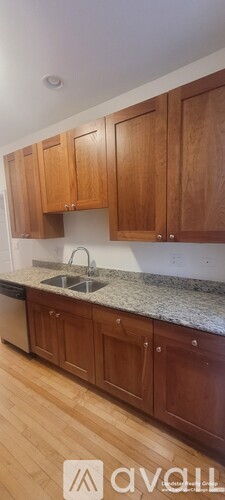 Brown wooden kitchen cabinets with a sink.