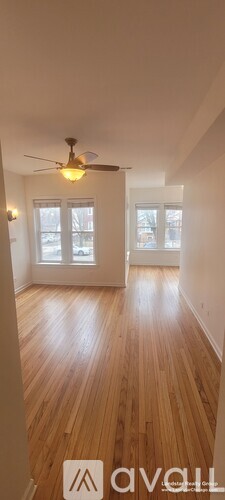 A room with wooden floors and a ceiling fan.