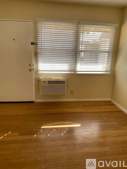A room with a white door and a window with blinds.
