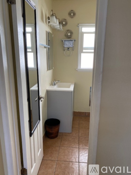 A bathroom with a toilet, sink, and mirror.