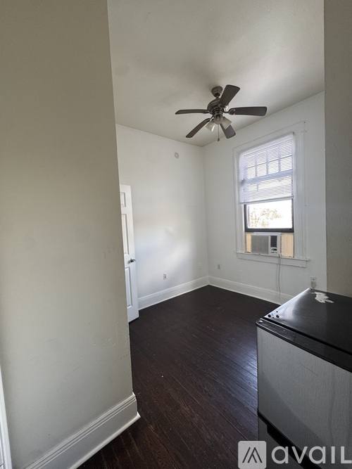 A room with a ceiling fan and a window.