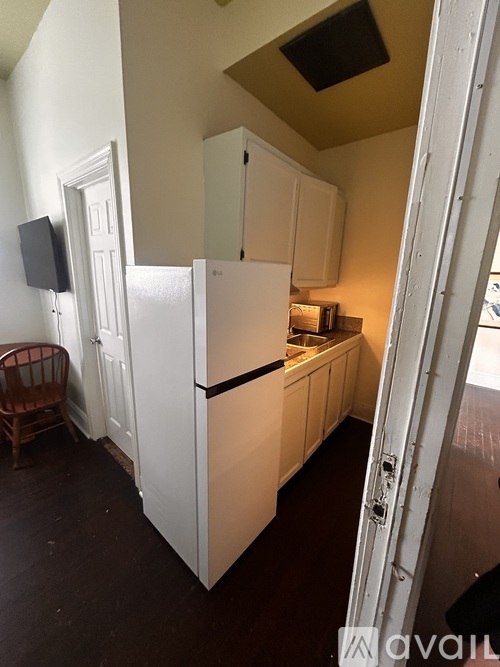 A kitchen with white cabinets and a white fridge.