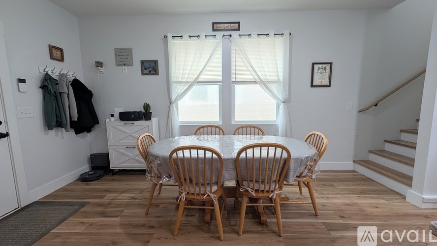 A dining room with a white table and chairs.