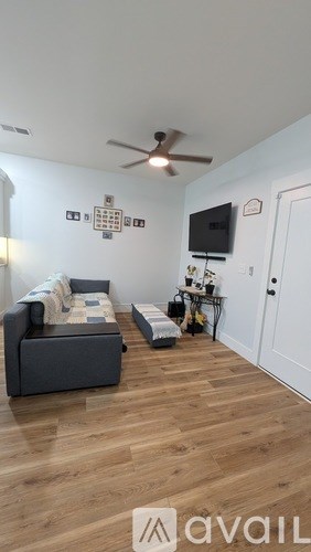 A living room with a grey couch and a white door.