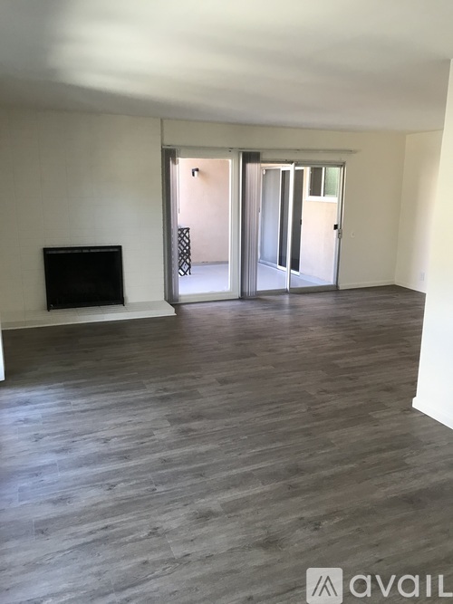 A spacious living room with a fireplace and sliding glass doors.