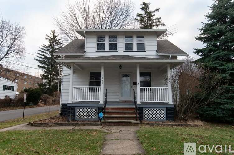 A white house with a black front door and a small porch.