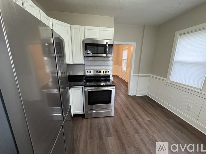 A kitchen with a refrigerator, oven, and microwave.