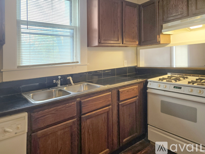 A kitchen with wooden cabinets and a white stove.