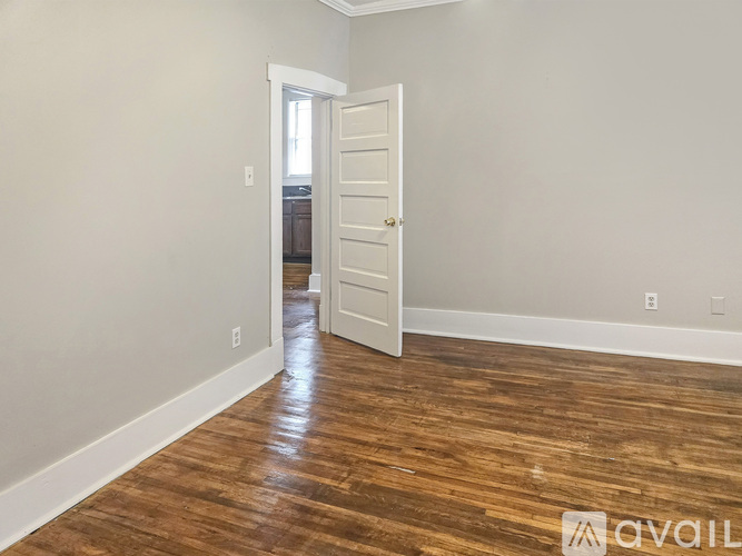 A room with wooden flooring and a white door.