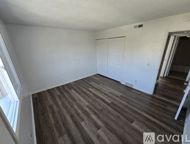 A room with wooden flooring and a white door.