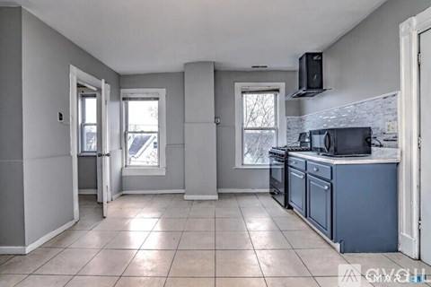 A kitchen with a blue cabinet and a black stove top oven.