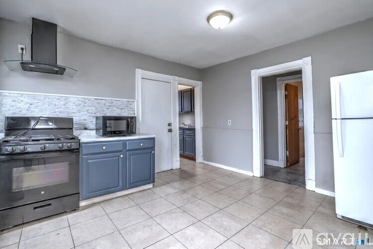 A kitchen with a white refrigerator, a black stove, and a white oven.
