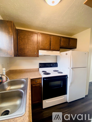 A kitchen with a white fridge and a black stove top.